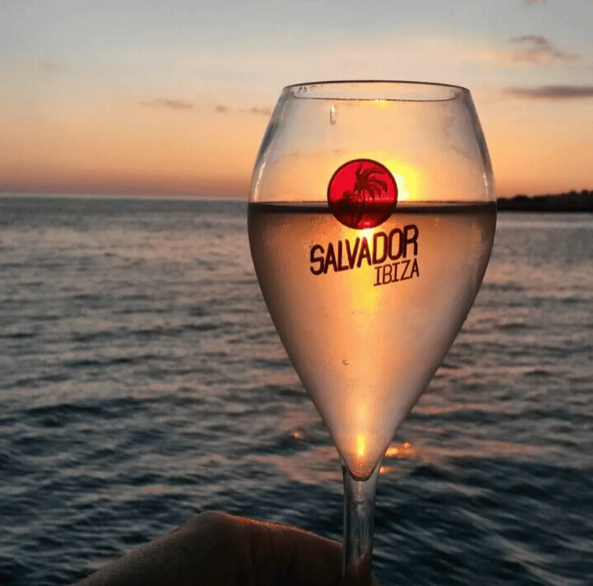 Copa de cava en crucero al atardecer en Salvador Ibiza