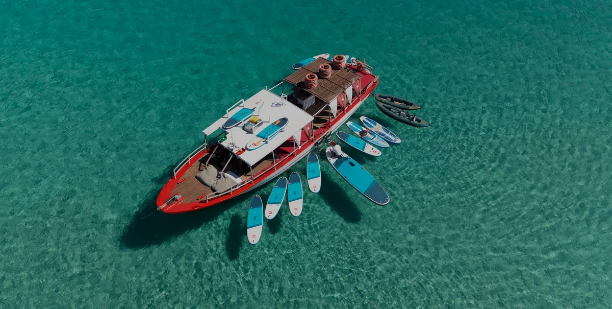 Vista aérea del Salvador Ibiza en Cala Comte con agua turquesa y sombras de paddleboards